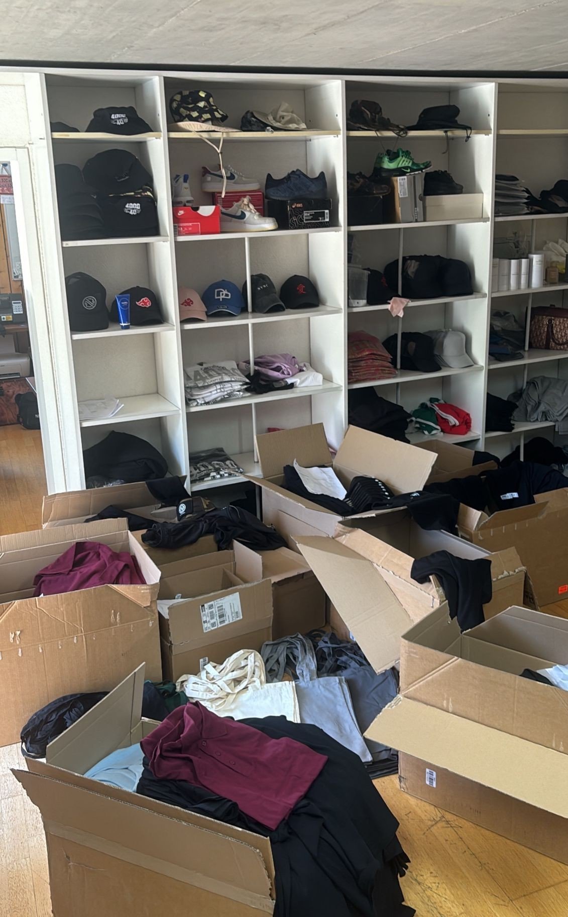 Atelier NVNC à Sierre — étagères de stock textile et cartons de production